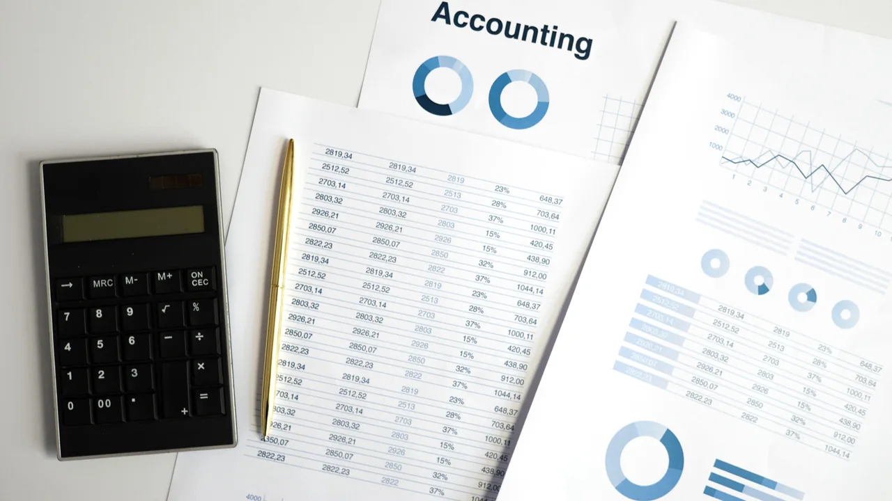 Hojas de contabilidad con columnas de cifras junto a una calculadora