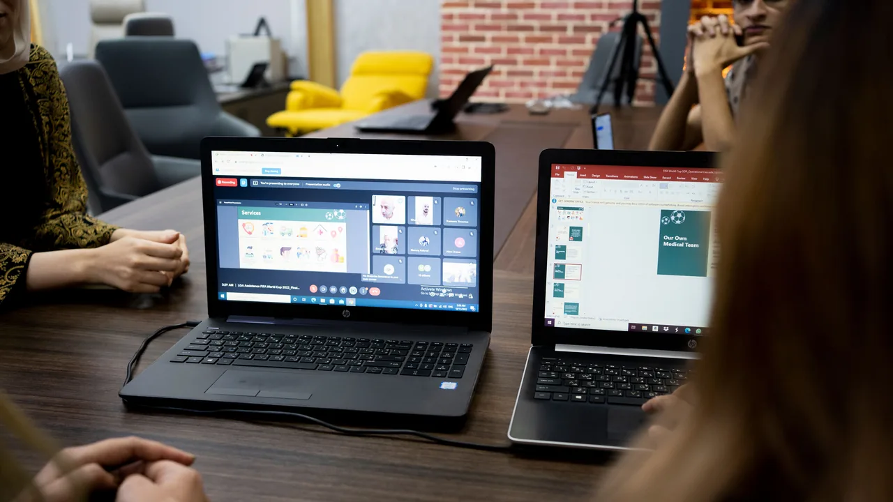 Dos portátiles abiertos con documentos en pantalla en una mesa