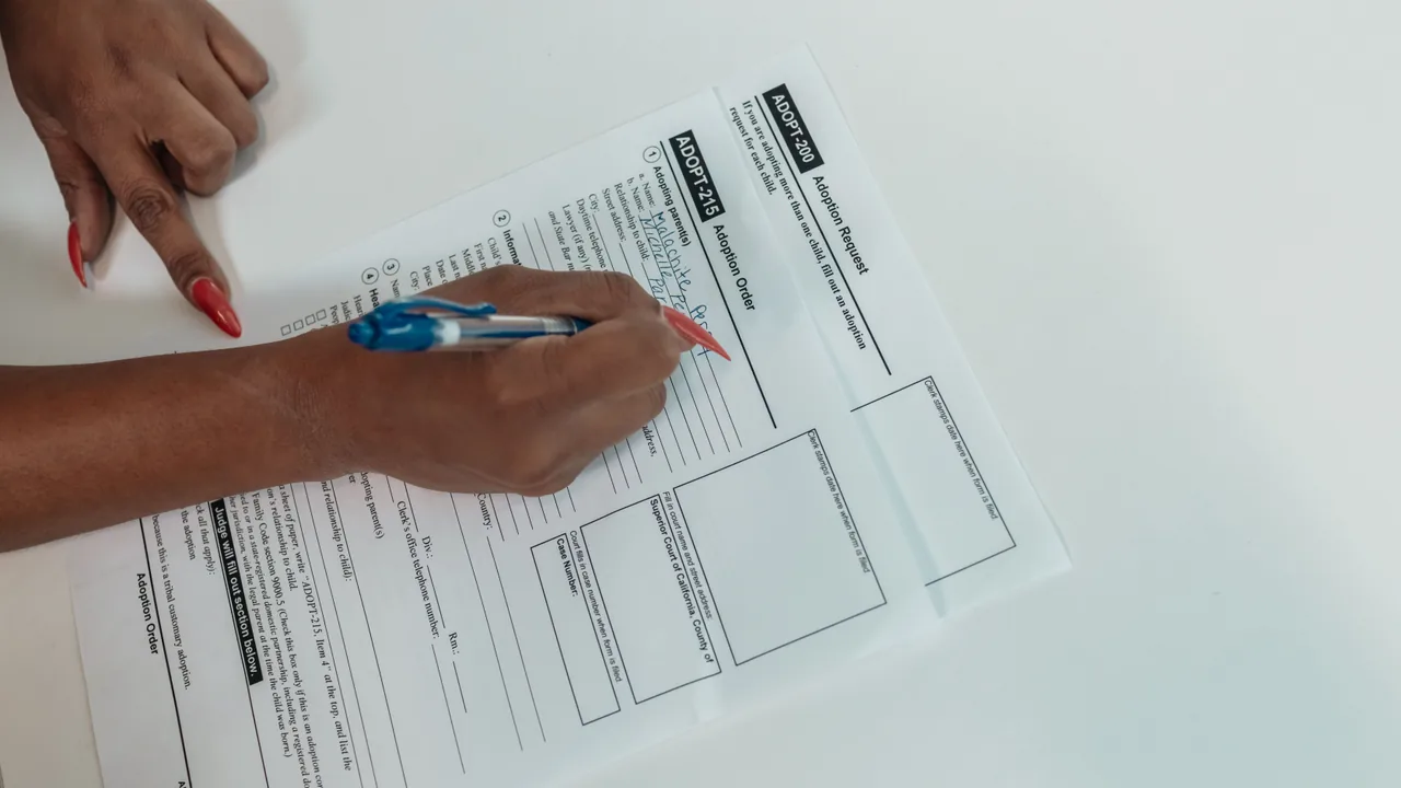 Manos rellenando a mano un formulario tributario