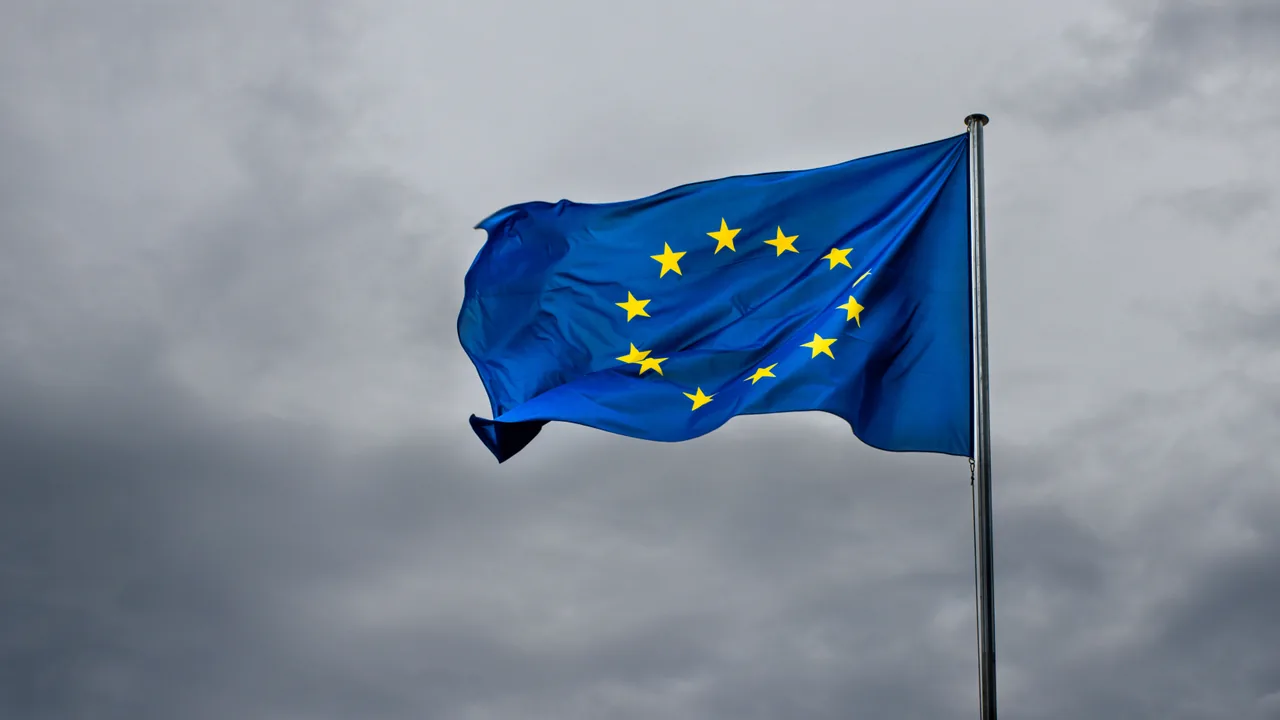 Bandera de la Unión Europea ondeando contra un cielo gris